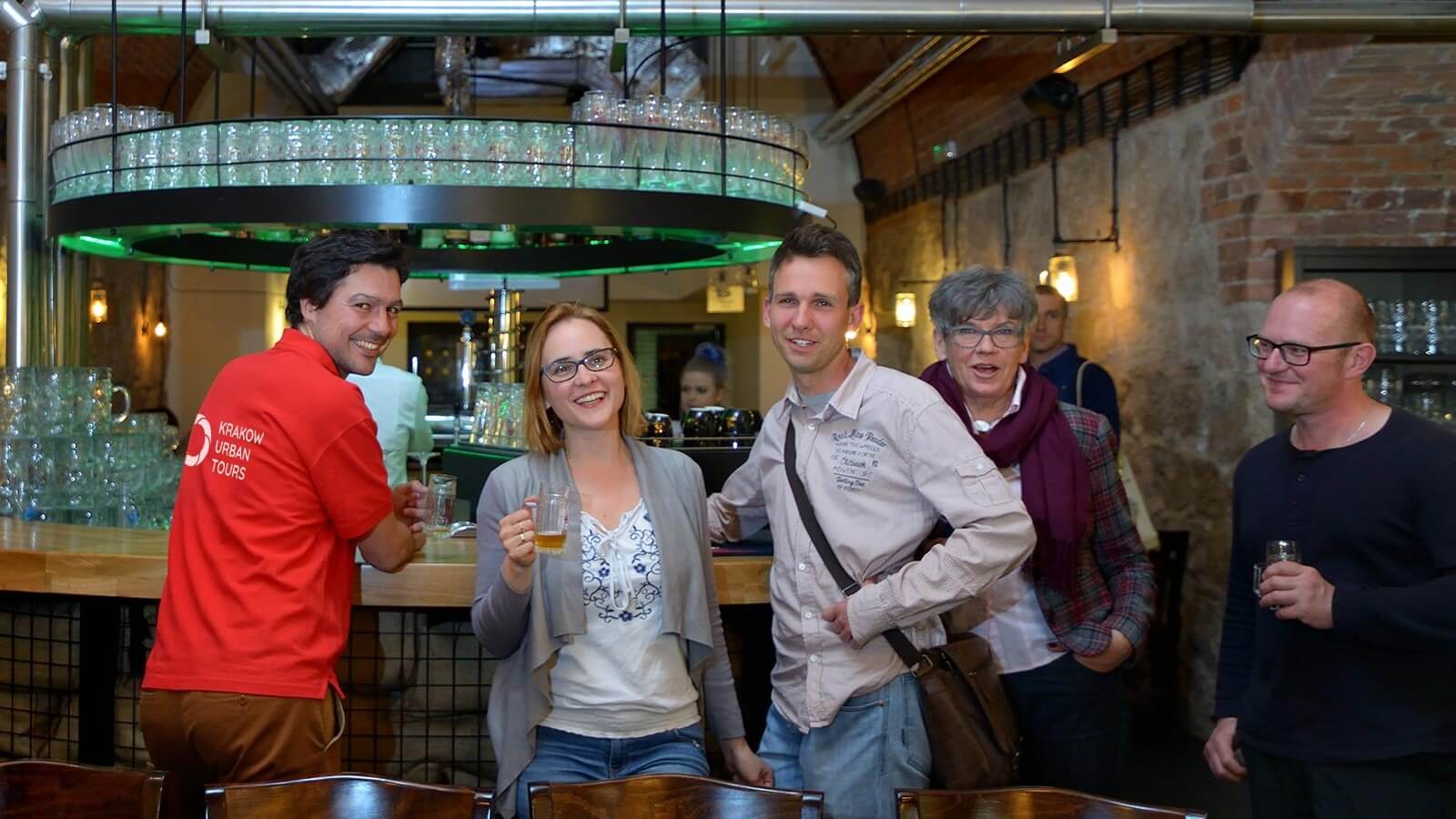 Guests enjoying drinks with a local guide on a private Krakow beer tour in a historic bar.